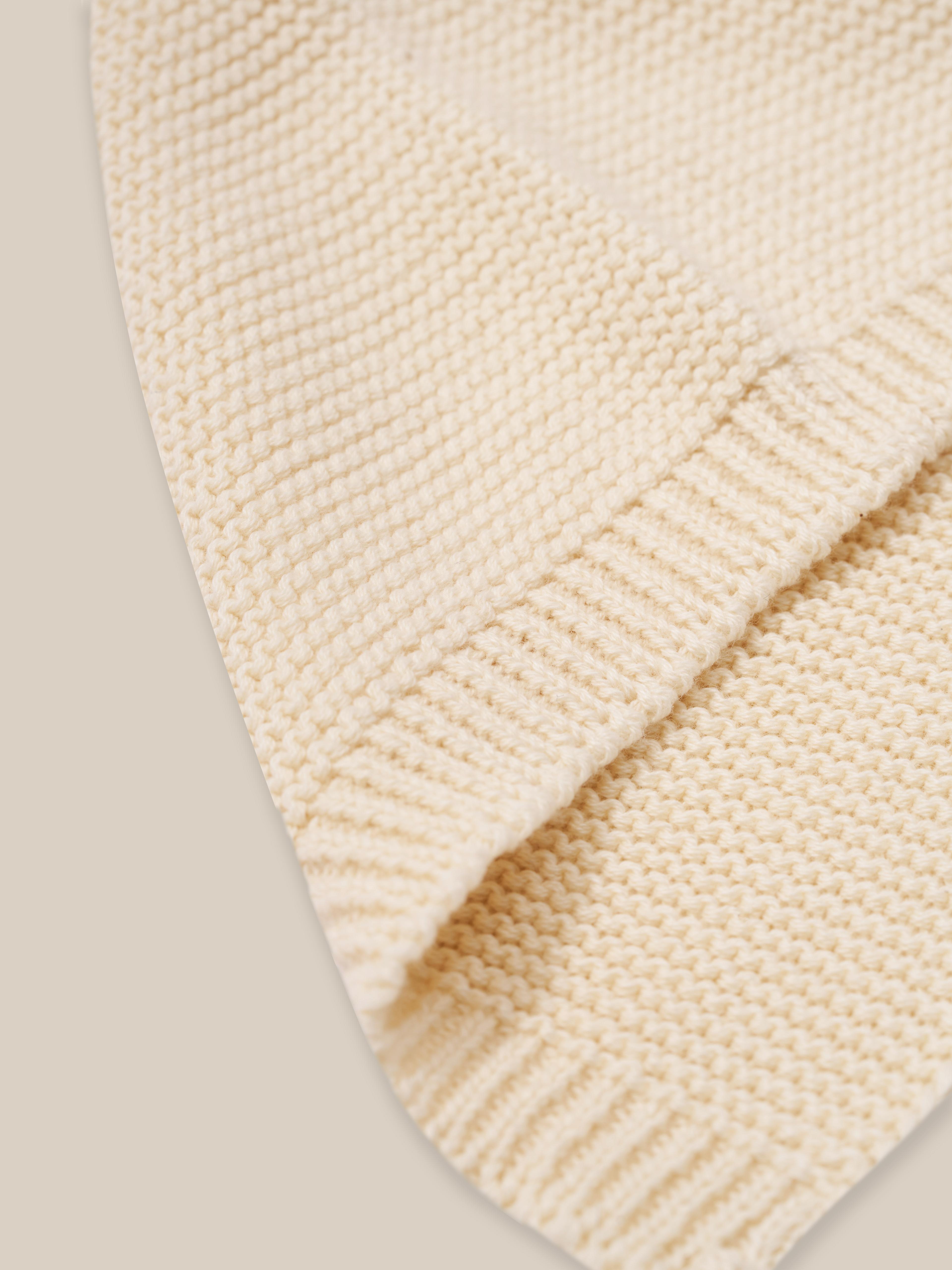 close up of undyed cotton cream knitted pixie hat with chin tie