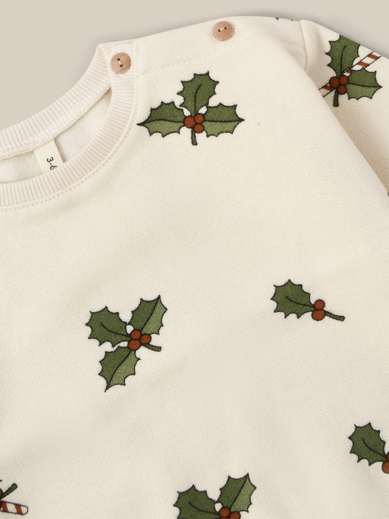 close up of cream brushed french cotton christmas sweatshirt with holly & candy cane prints