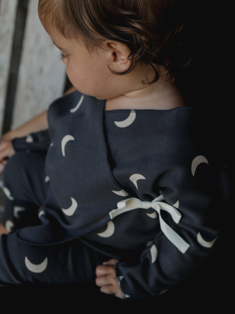 baby in matching set black kimono with cream moons & white bow detail & leggings 