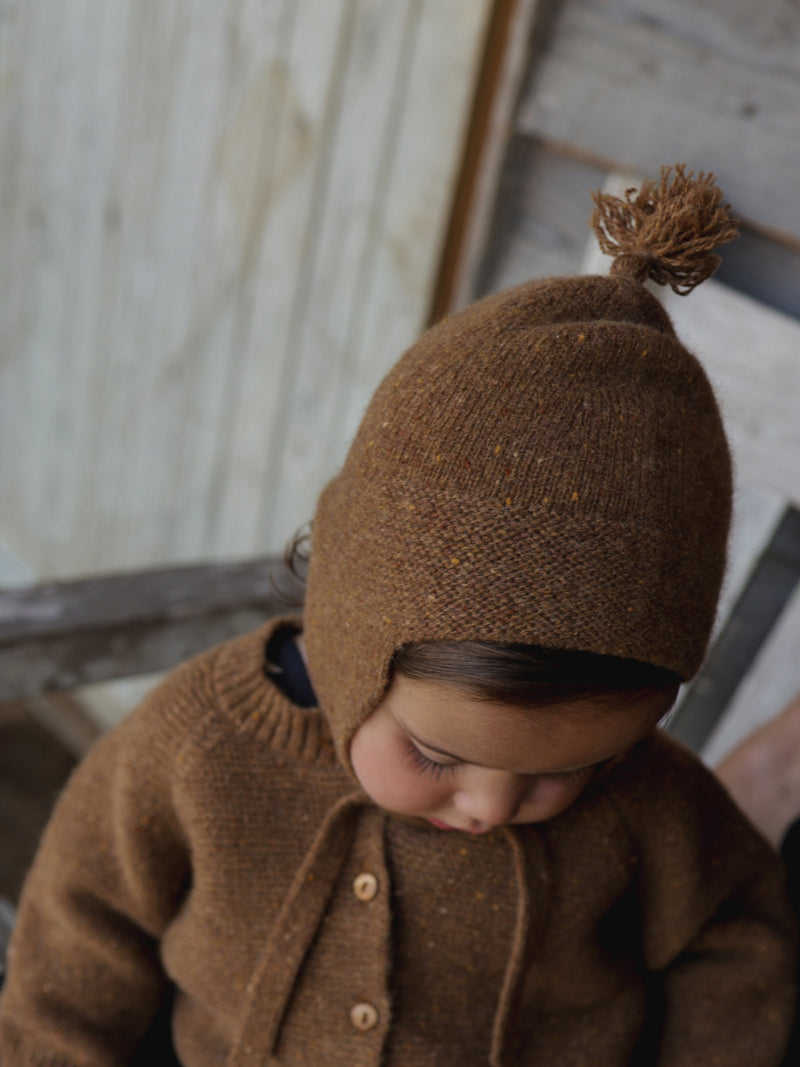 baby dressed in brown wool tassel hat with chin tie & matching wool cardigan