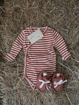 baby red & white stripes wrap bodysuit & red booties on farm straw