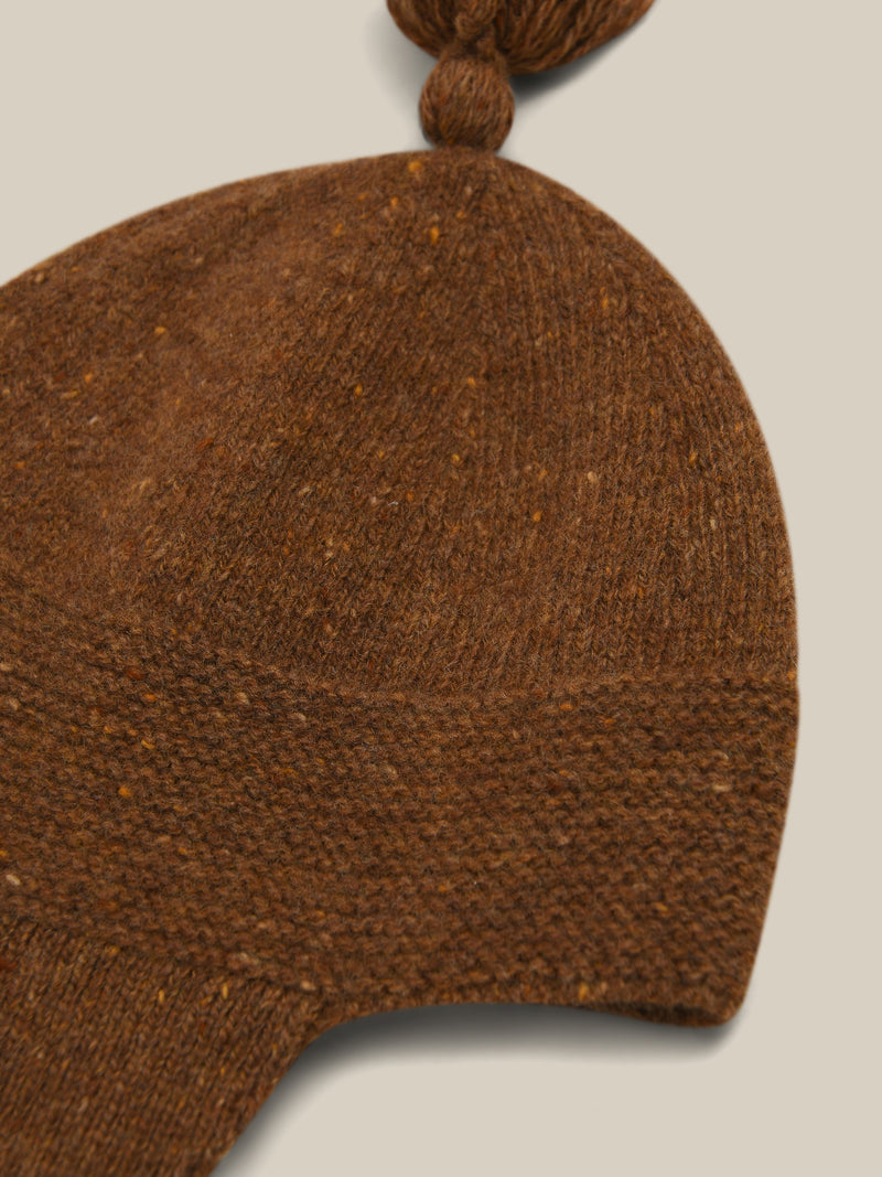 close up of wool hat in brown with tassel and chin tie