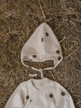 baby & toddler bodysuit in cream with brown dots & matching pixie bonnet on straw crops