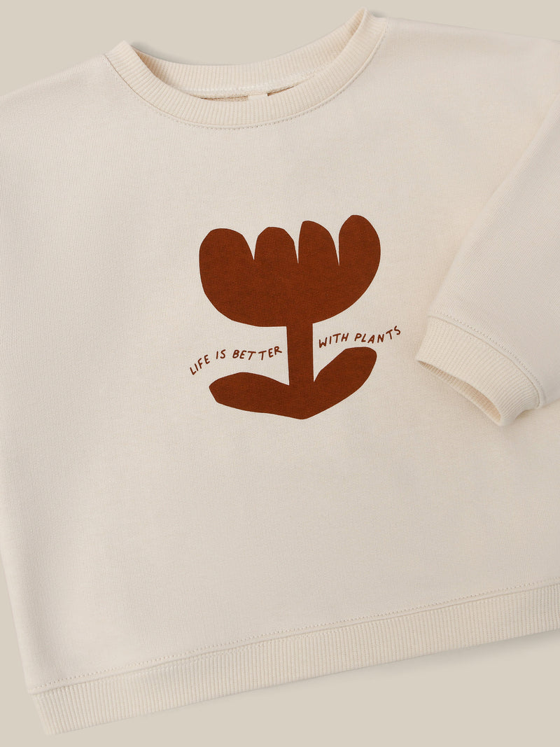 close up of undyed cotton sweatshirt in cream with plant print LIFE IS BETTER WITH PLANTS slogan