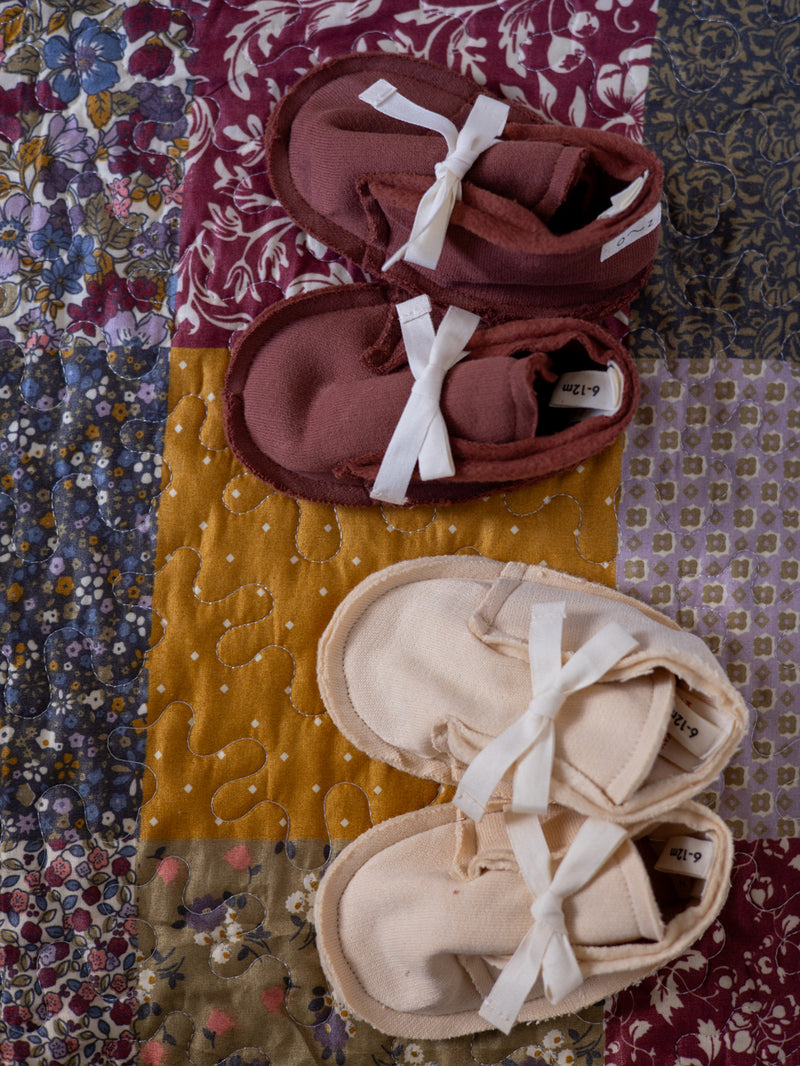 baby & toddler cream & red terry cotton booties with white bows on patchwork quilt