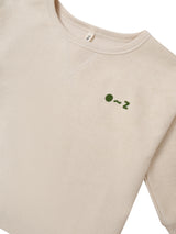 close up of cream undyed cotton sweatshirt with O ~ Z embroidered in green