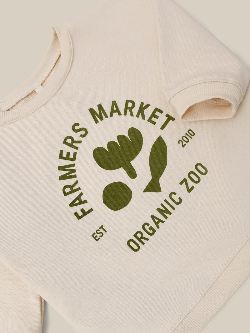 close up of sweatshirt in cream with green ORGANIC ZOO FARMERS MARKET logo & prints