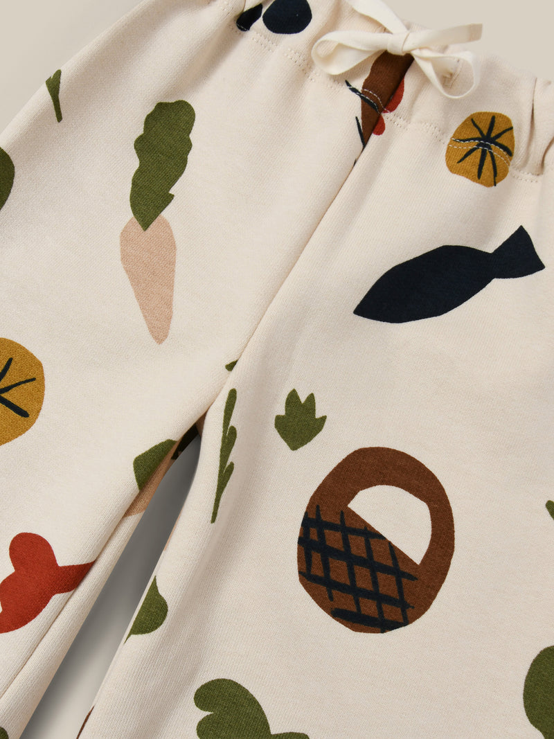 close up of undyed cotton cream wide leg pants with fruits vegetables & basket prints