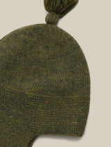 close up of wool hat in dark green with tassel and chin tie