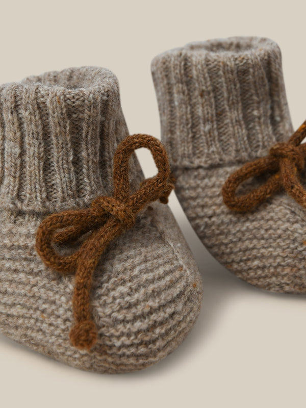 close up of wool booties in cream with brown ribbons