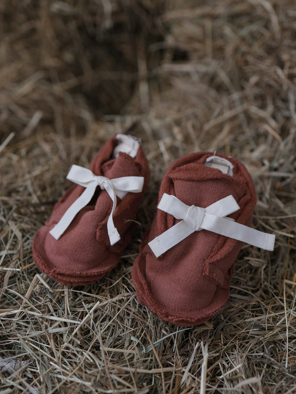 baby & toddler red earth terry cotton booties with white bows on straw bales