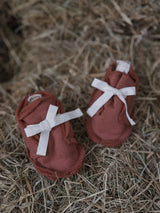 baby & toddler red terry cotton booties with white ribbons on straw bales farm