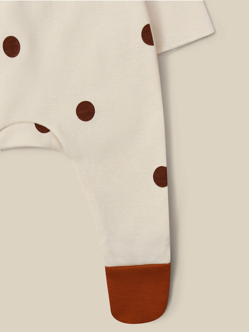 close up of footed suit in cream with brown dots & feet popper-down front