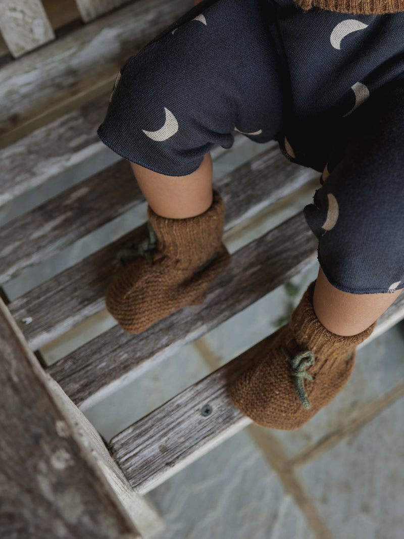 baby wearing leggings & wool baby booties in chestnut brown with dark green ribbons 