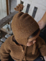 baby wearing matching knitwear chestnut brown wool hat with tassel & wool cardigan