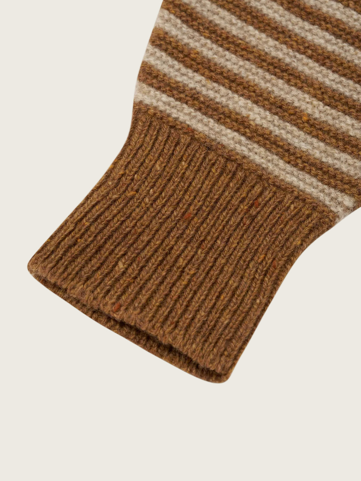 Close-up of a ribbed knit sock cuff in a warm brown tone, with horizontal stripes in brown and cream above the cuff, on a white background.