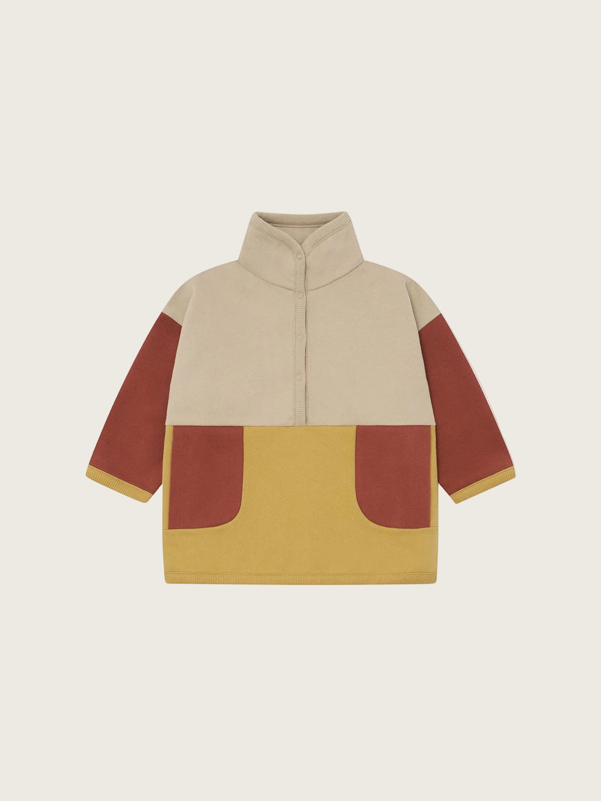 A colour-blocked children's sweatshirt with a beige upper body, rust-coloured sleeves, and a mustard yellow lower section with two matching rust pockets, shown on a plain white background.