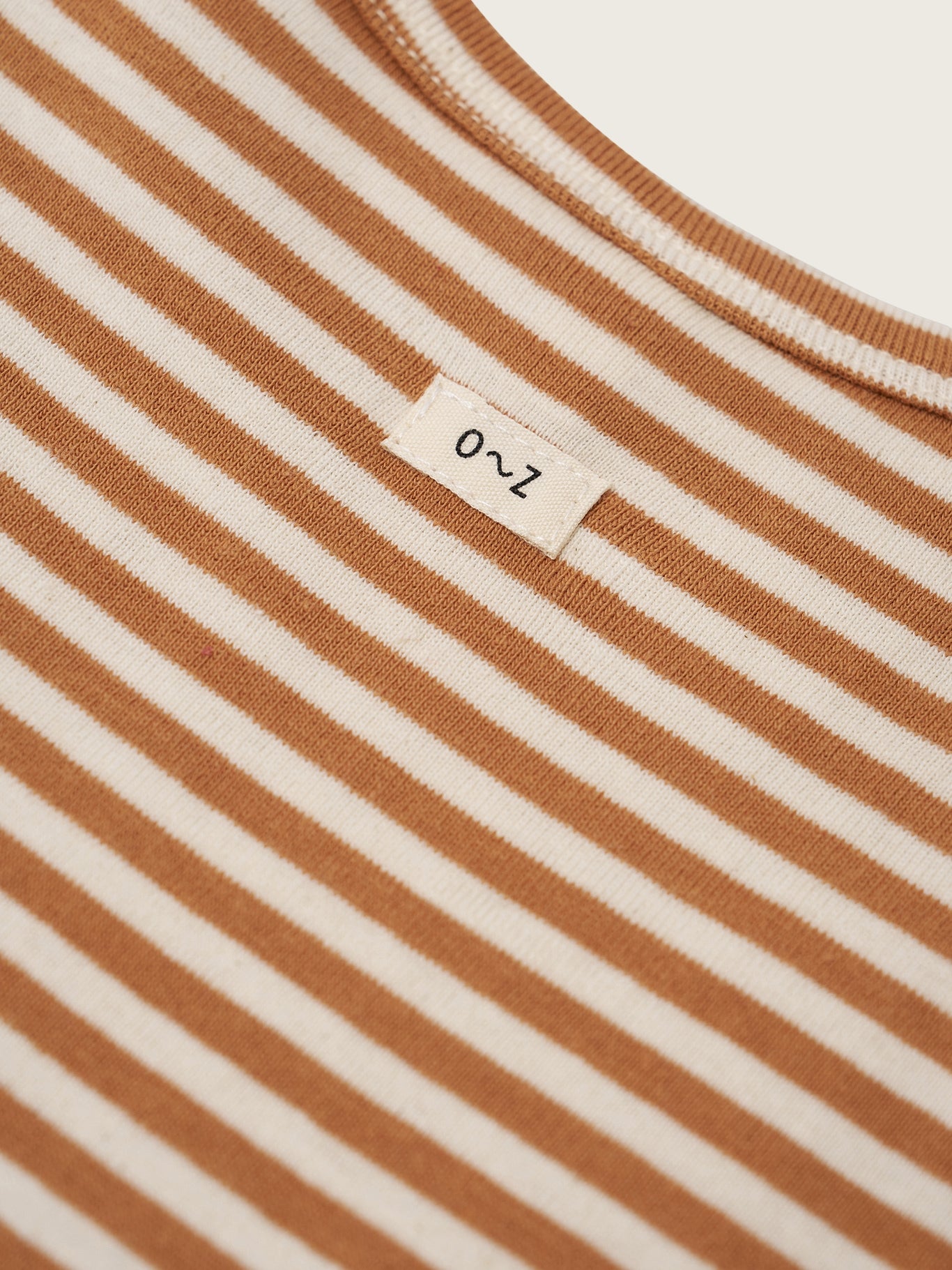 Close-up of a brown and white striped fabric with a label on a white background