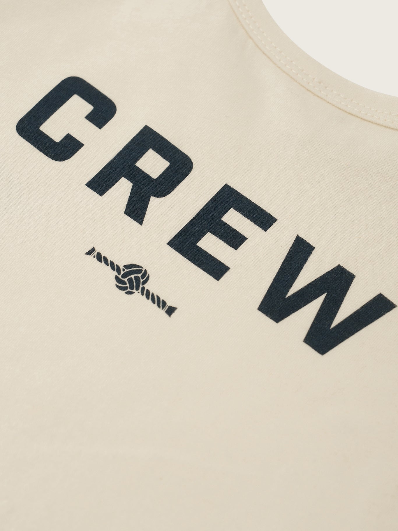 Beige sleeveless top with 'CREW' text and logo on a beige background