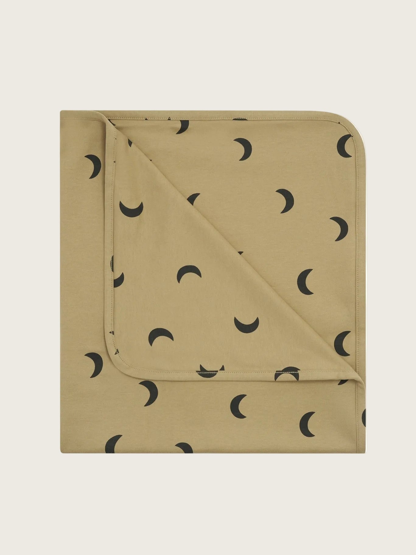 A folded baby blanket in a warm tan color, patterned with small black crescent moon shapes, shown on a plain white background.