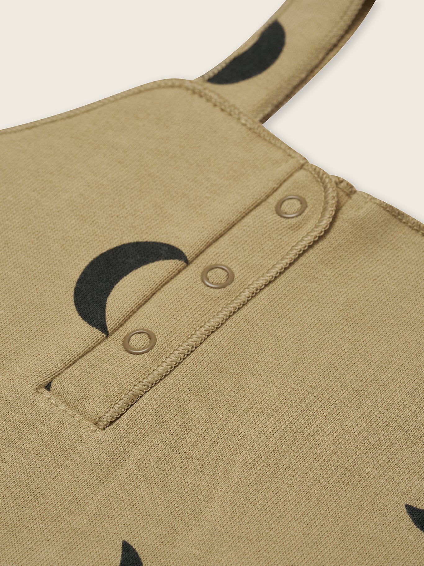 close up of dusky beige terry cotton salopette with black crescent print