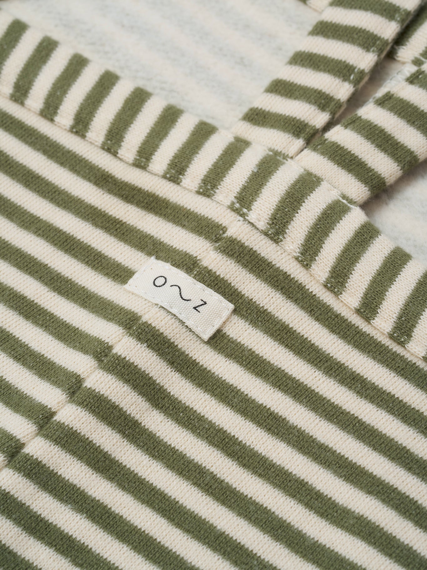 close up of toddler oversized boxy terry cotton dungarees with green and white stripes