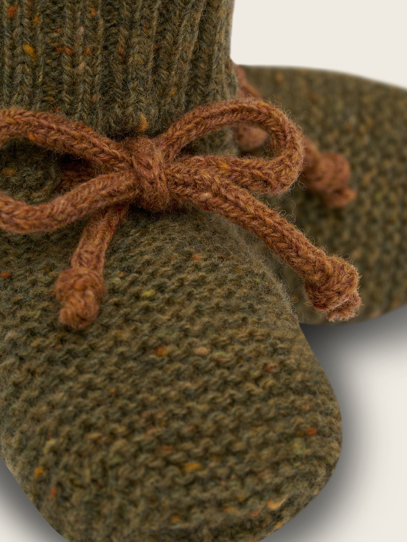 close up of wool booties in forest green with ribbed cuffs and brown ribbons