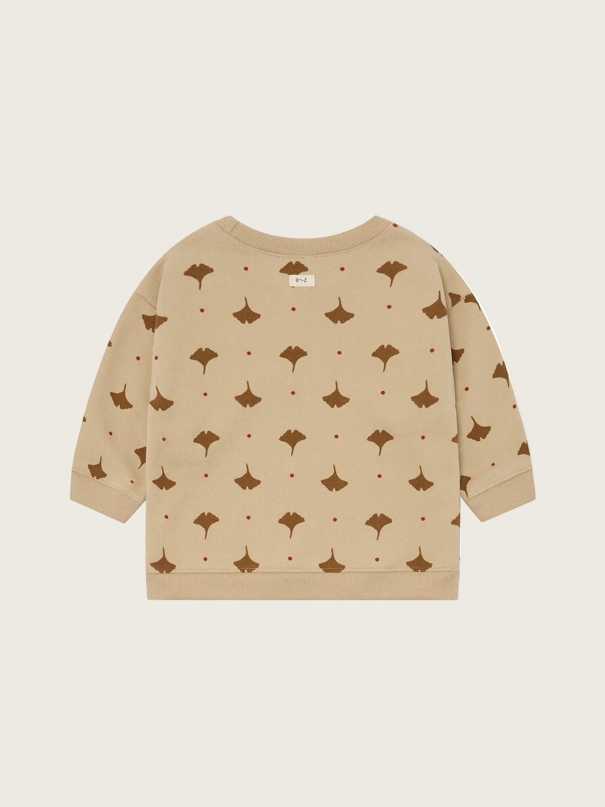 A beige long-sleeve sweatshirt with an all-over print of brown ginkgo leaves and small red dots, shown flat against a solid white background.
