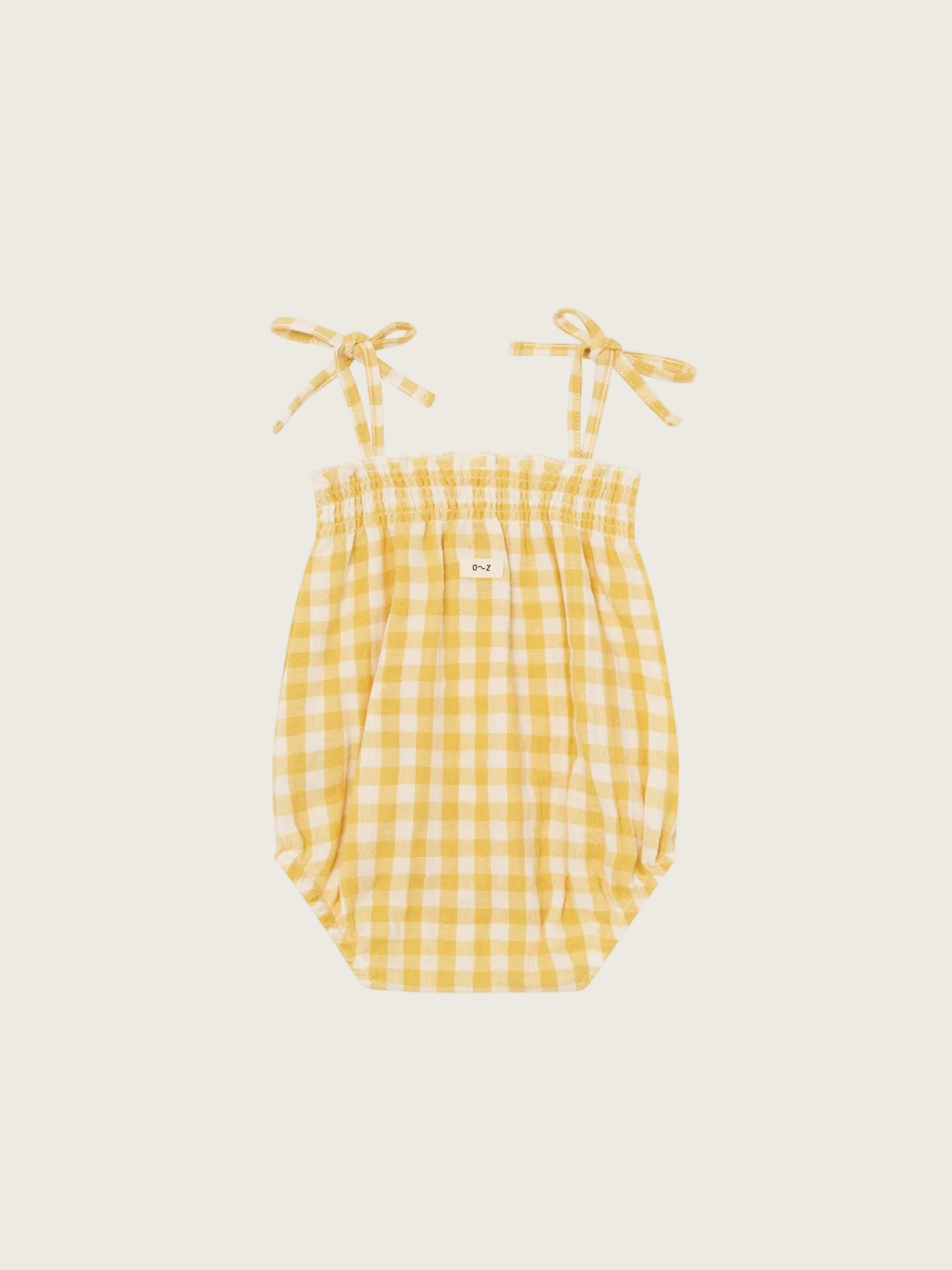 Yellow gingham baby romper with straps on a white background