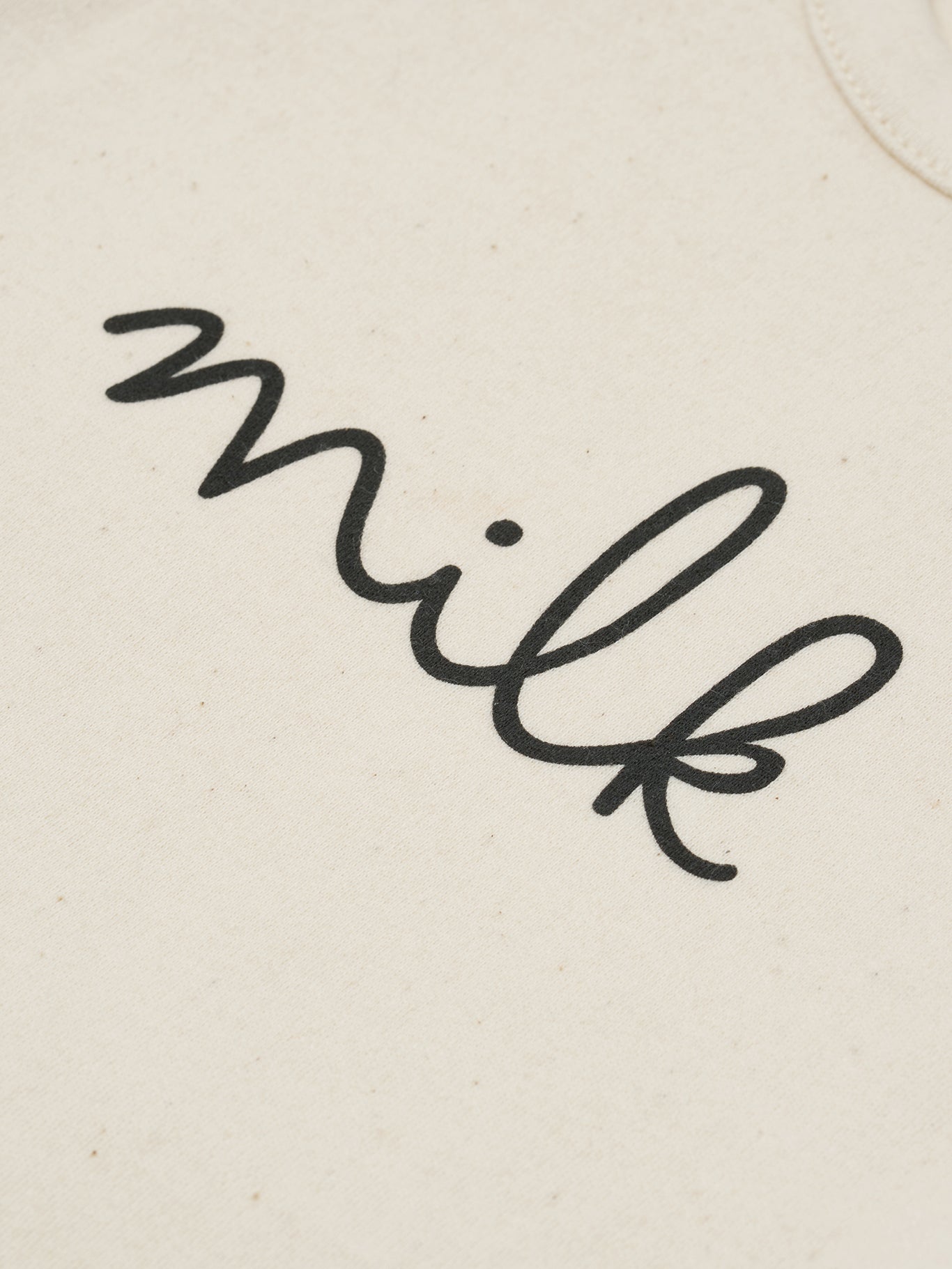 close up of baby cream undyed cotton bodysuit with milk text