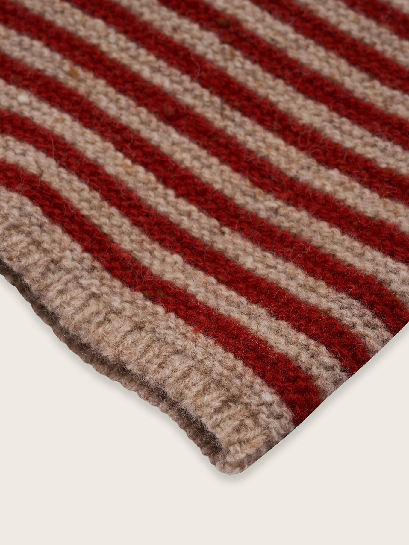 close up of beige wool boat neck jumper with paprika red stripes