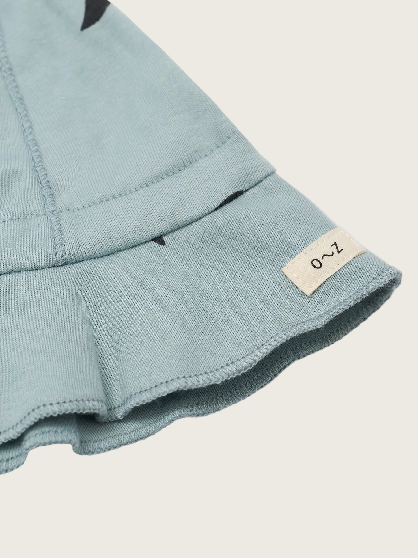 Close-up of a light blue fabric with a brand label on a white background