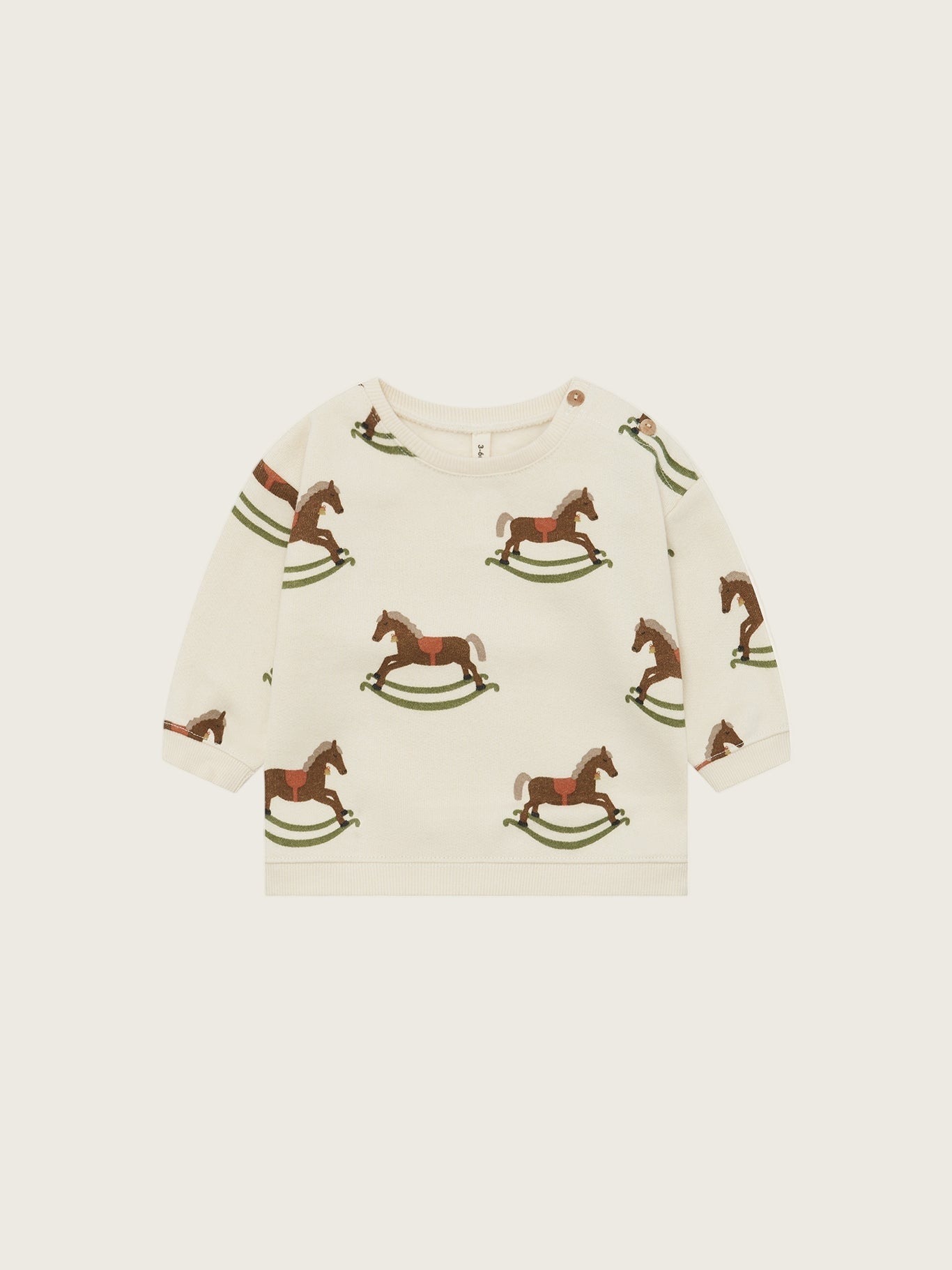 Children's sweater with rocking horse pattern on a beige background