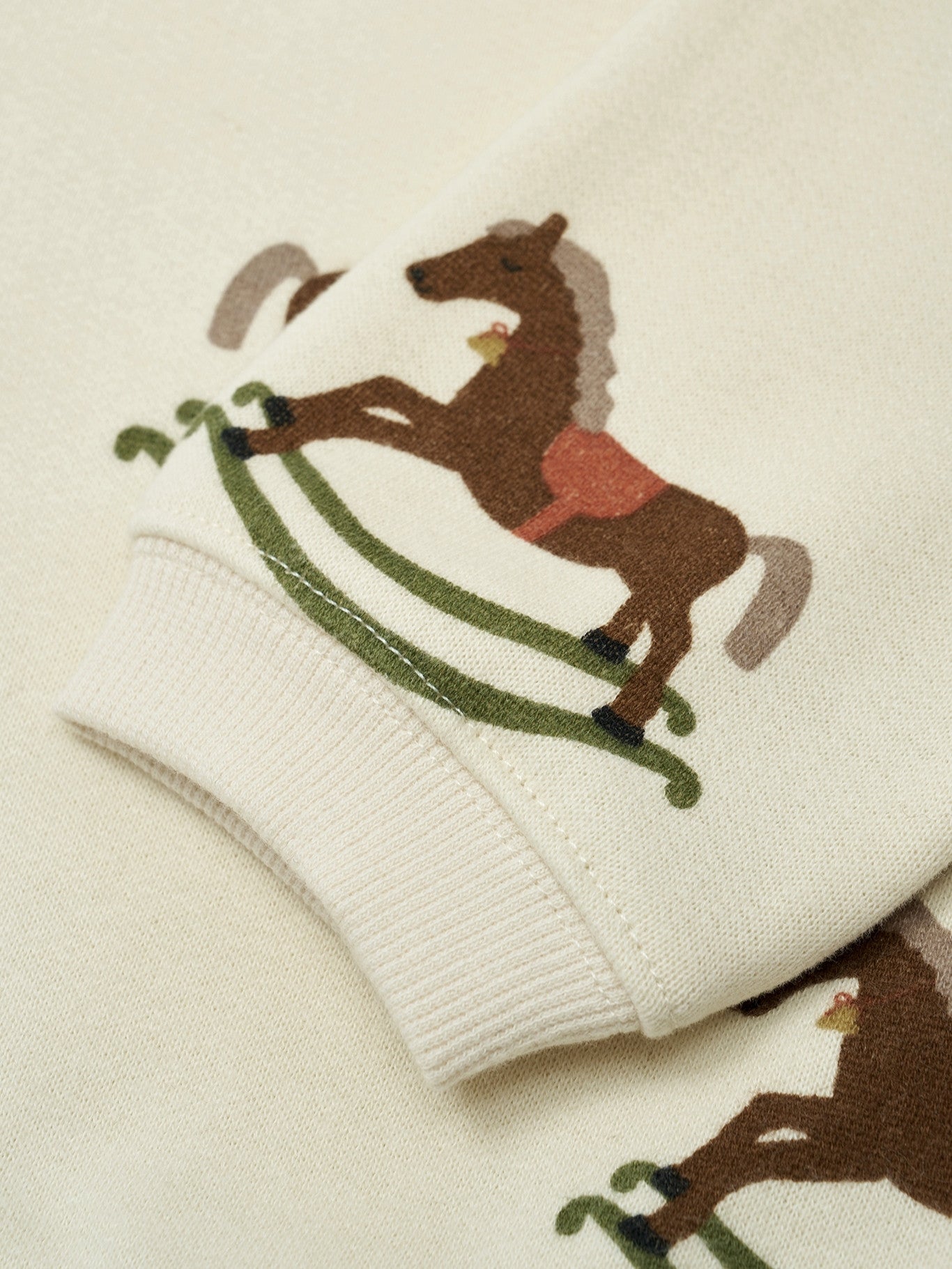 Close-up of embroidered horse design on a beige background