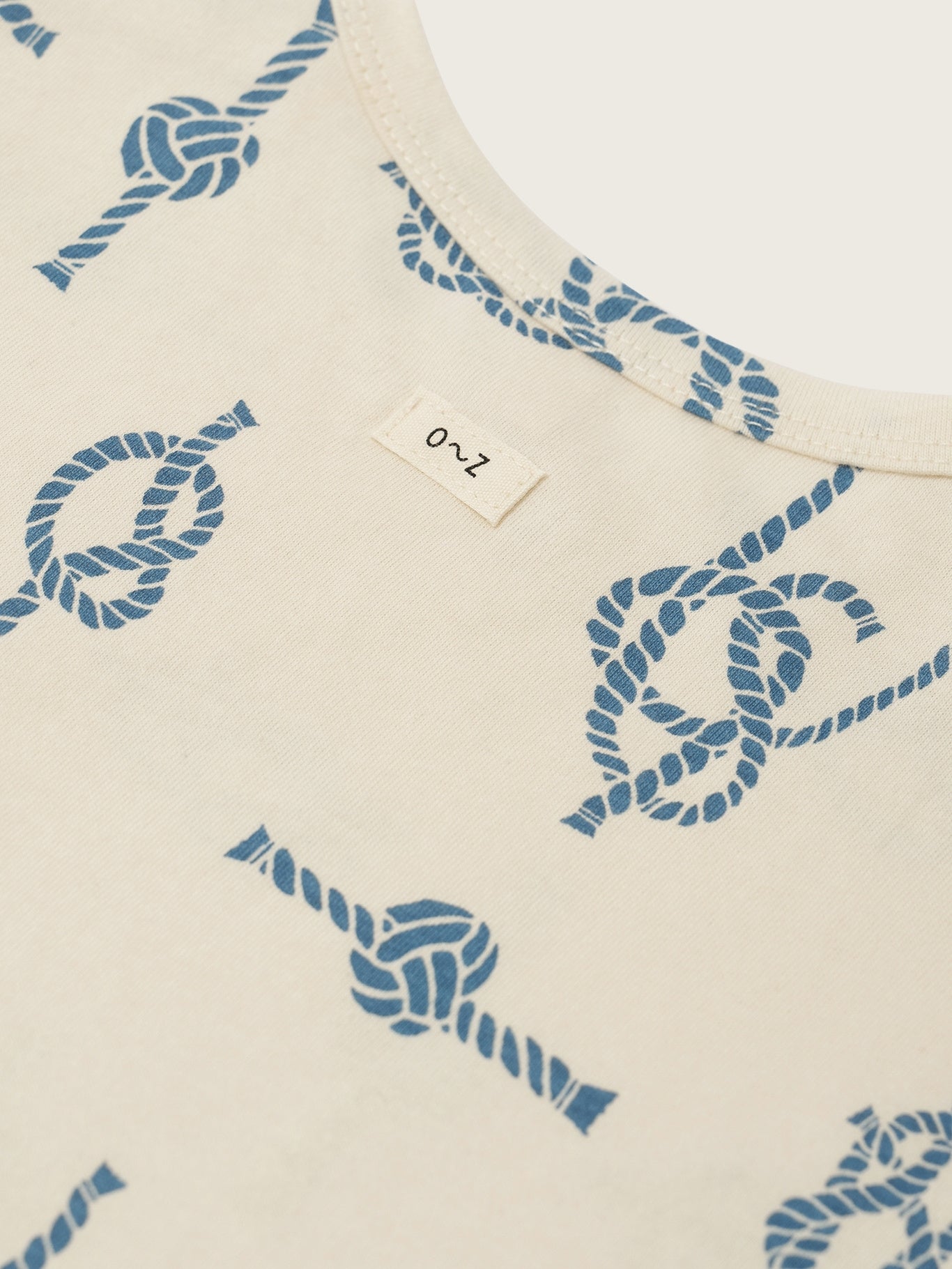 Beige fabric with blue rope pattern and a label on a white background
