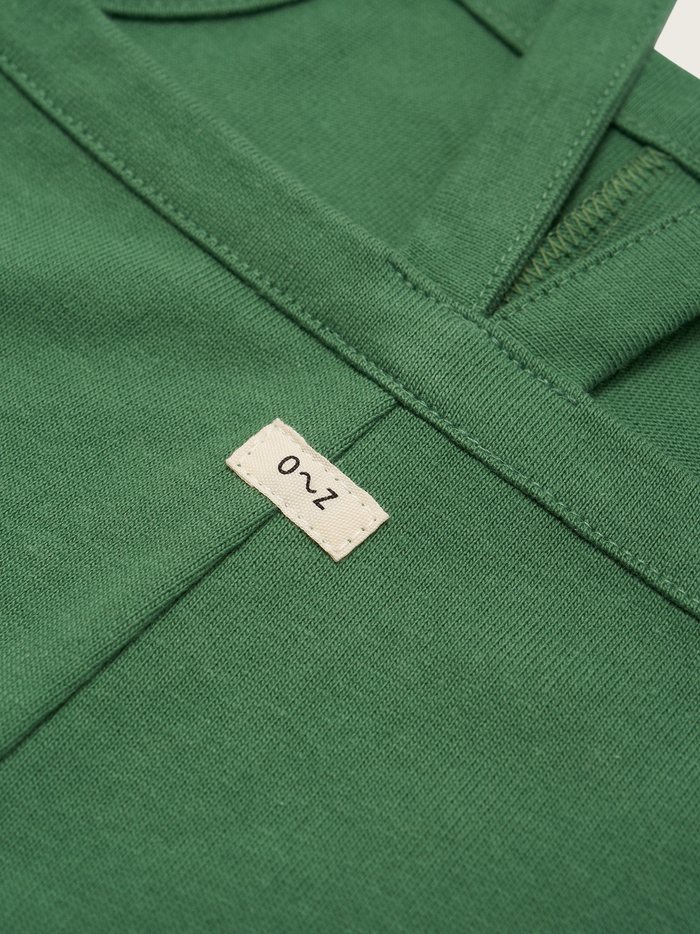 Close-up of a green garment with a brand label on it