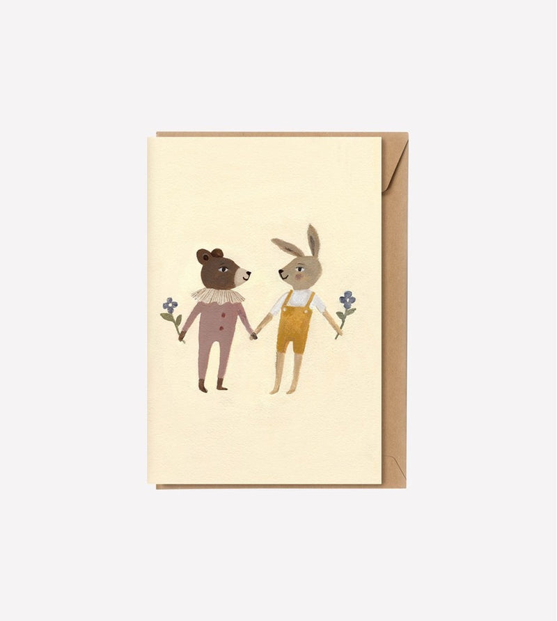 teddy in onesie hand-in-hand with bunny in overalls holding flowers printed on cream A5 greeting card