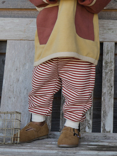 close up of toddler paprika red sweatpants with yellow sweatshirt & brown t-bar shoes