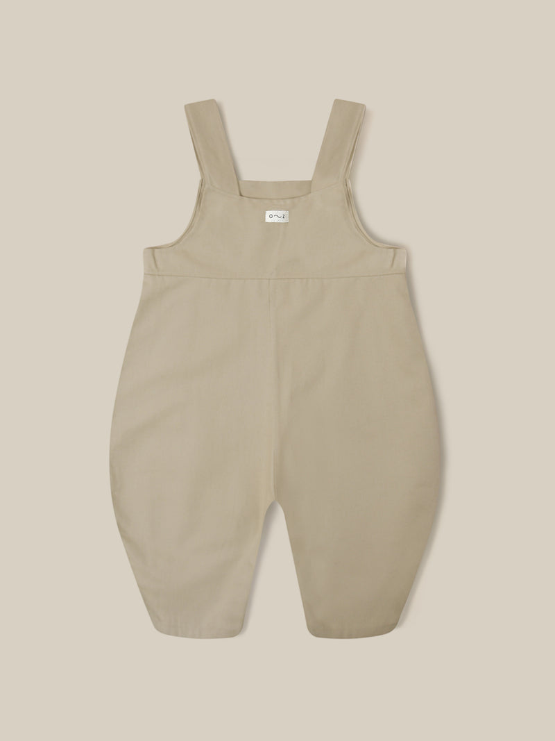 close up of twill cotton oversized farmers dungarees in grey with buttons & side in-seam pockets with gingham finish