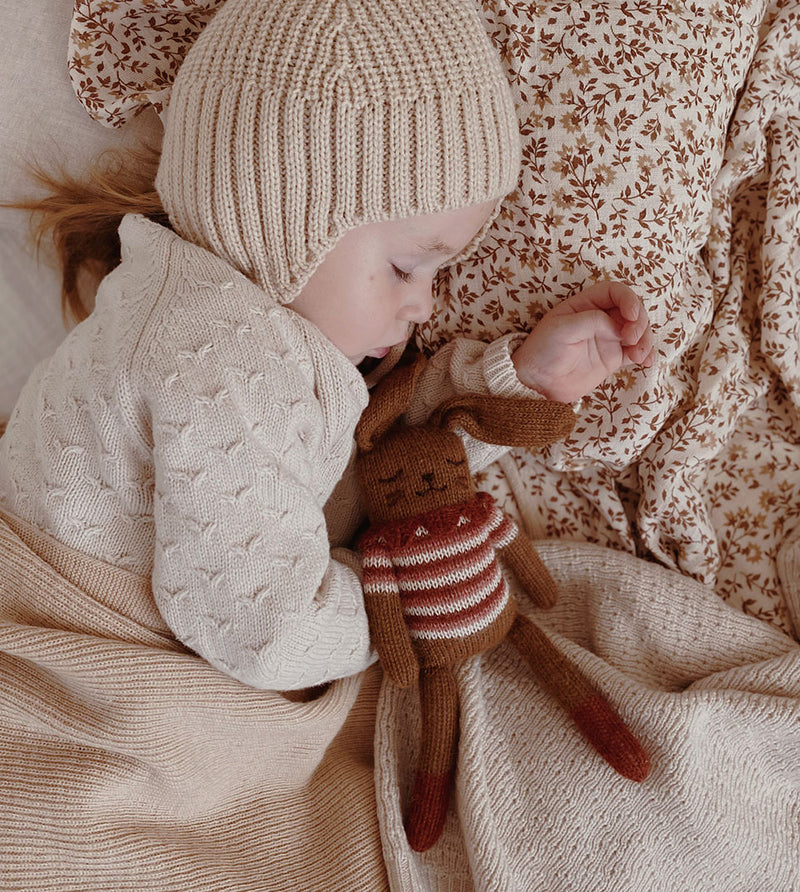 toddler sleeping with knitted wool bunny cuddly toy in sienna top