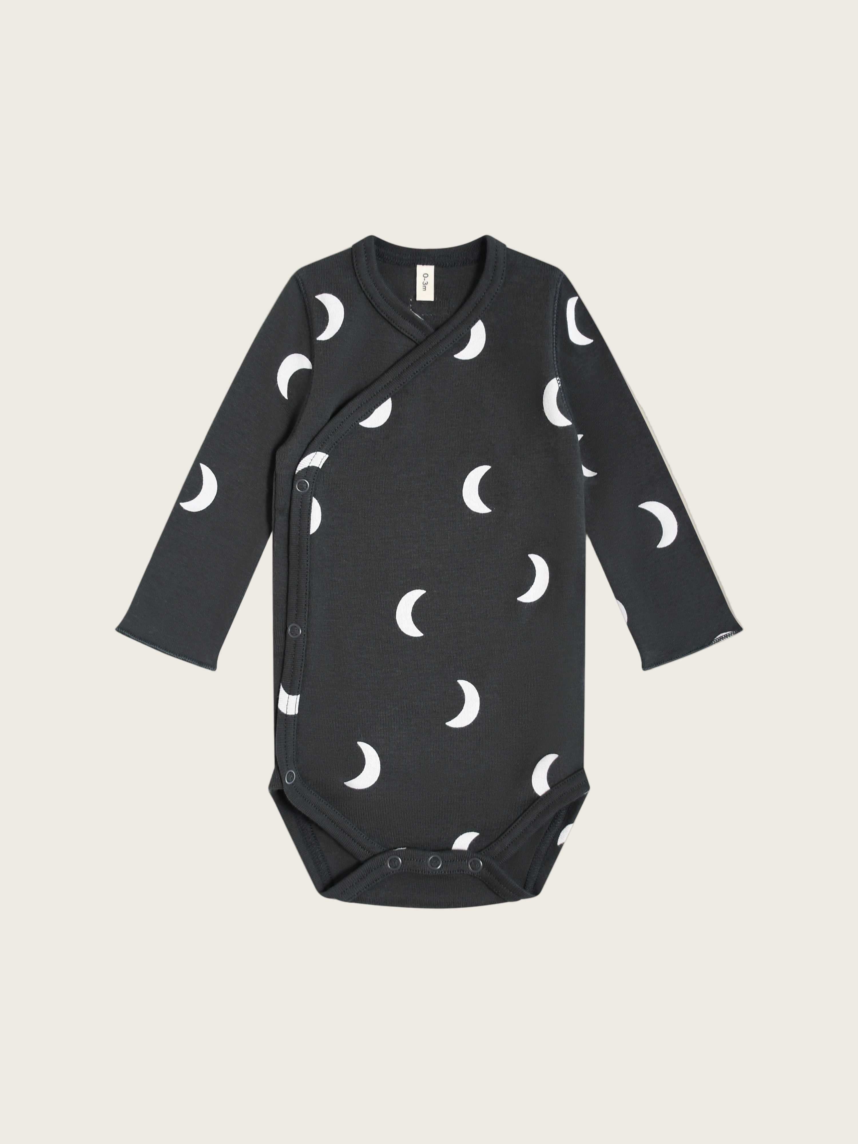A black bodysuit with a moon pattern designed for babies